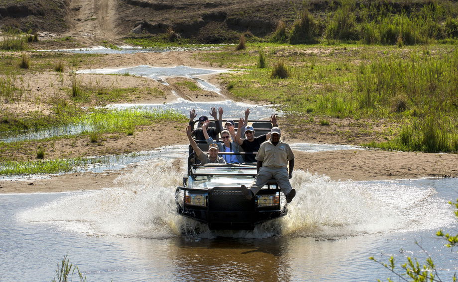 guests with guides crossing river in vehicle at &Beyond Tengile River Lodge Sabi Sands
