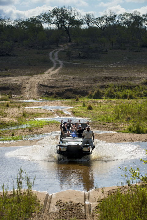 guests with guides crossing river in vehicle at &Beyond Tengile River Lodge Sabi Sands