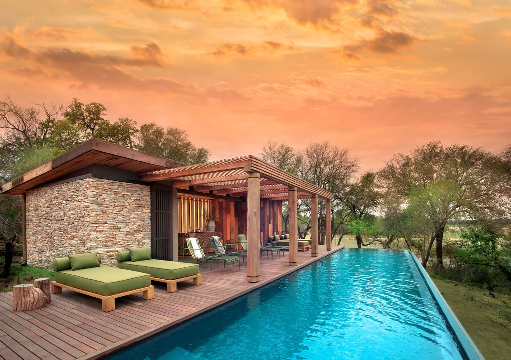 pool deck with loungers at sunset at &Beyond Tengile River Lodge Sabi Sands
