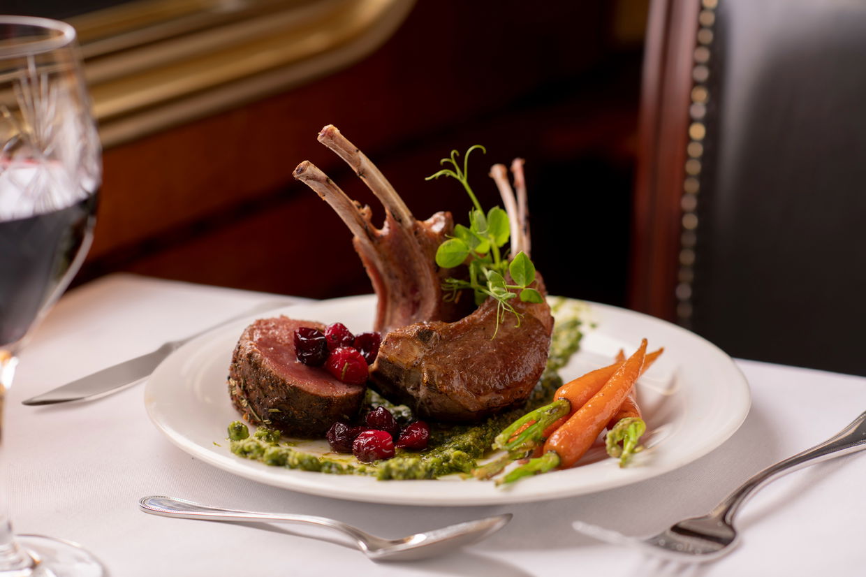 gourmet rack of lamb on white plate served by the blue train