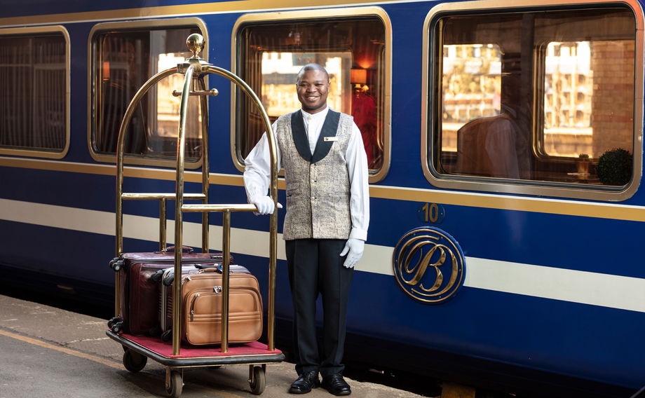 butler with luggage on platform of the blue train pretoria