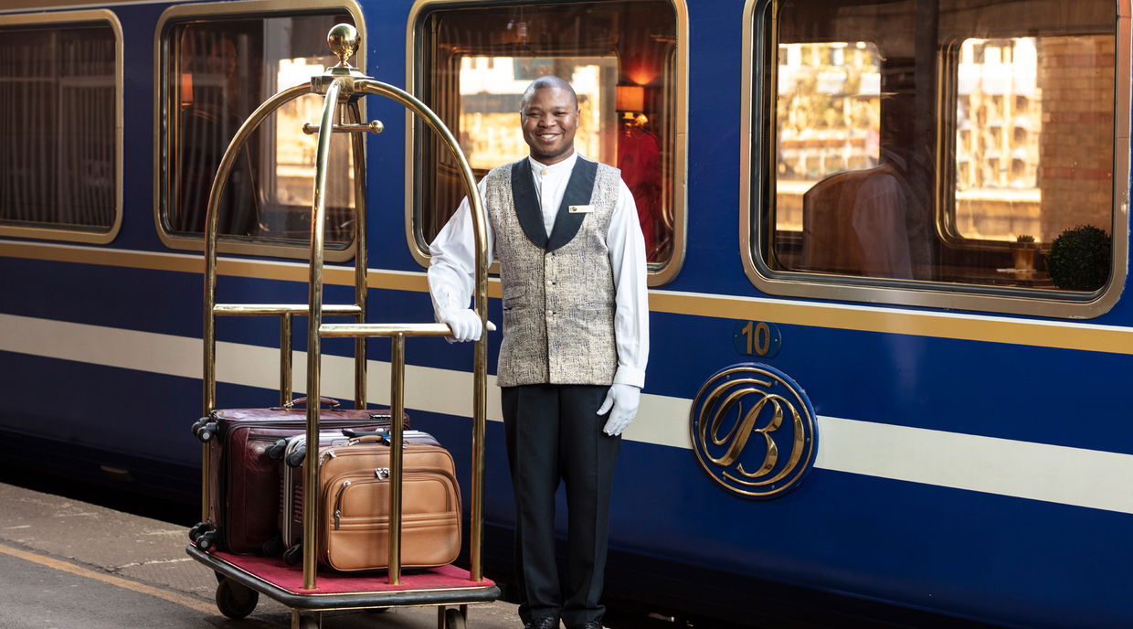 butler with luggage on platform of the blue train pretoria