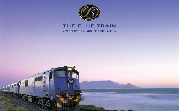 Blue train locomotive at sunset with table mountain cape town in background with logo overlay on image Blue train locomotive at sunset with table mountain cape town in background with logo overlay on image