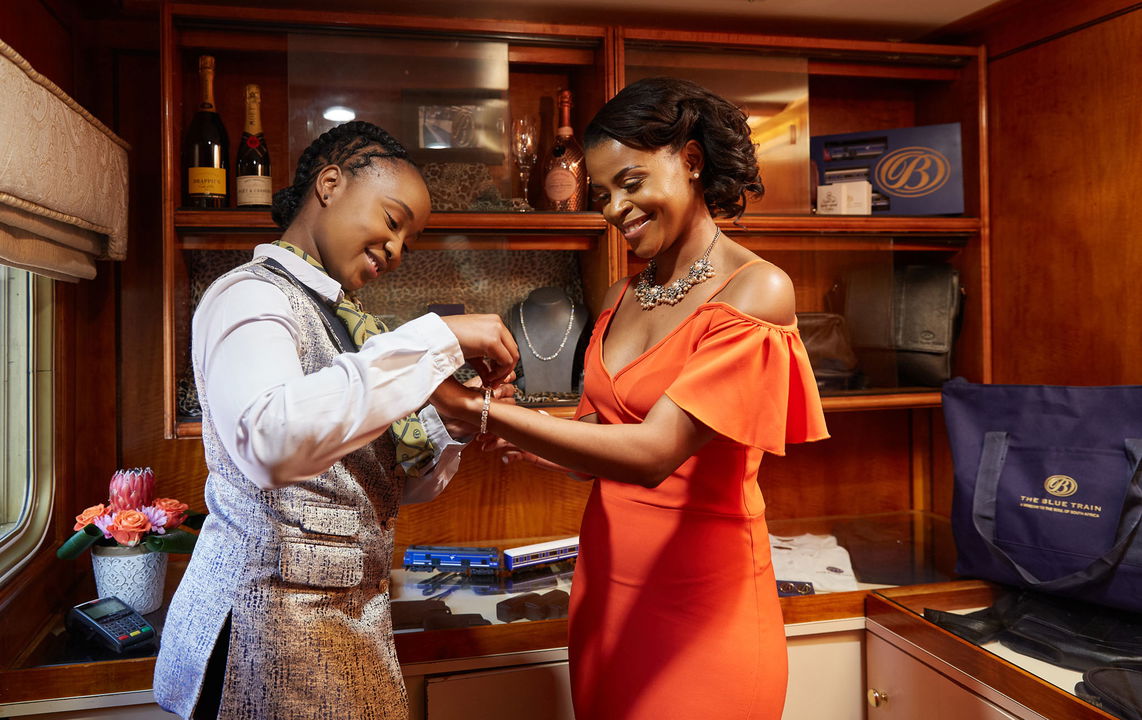lady guest trying on jewellery ion shop of the blue train south Africa