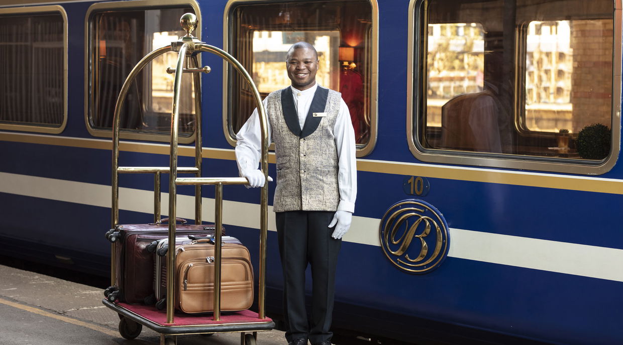 butler with luggage on platform of the blue train Pretoria
