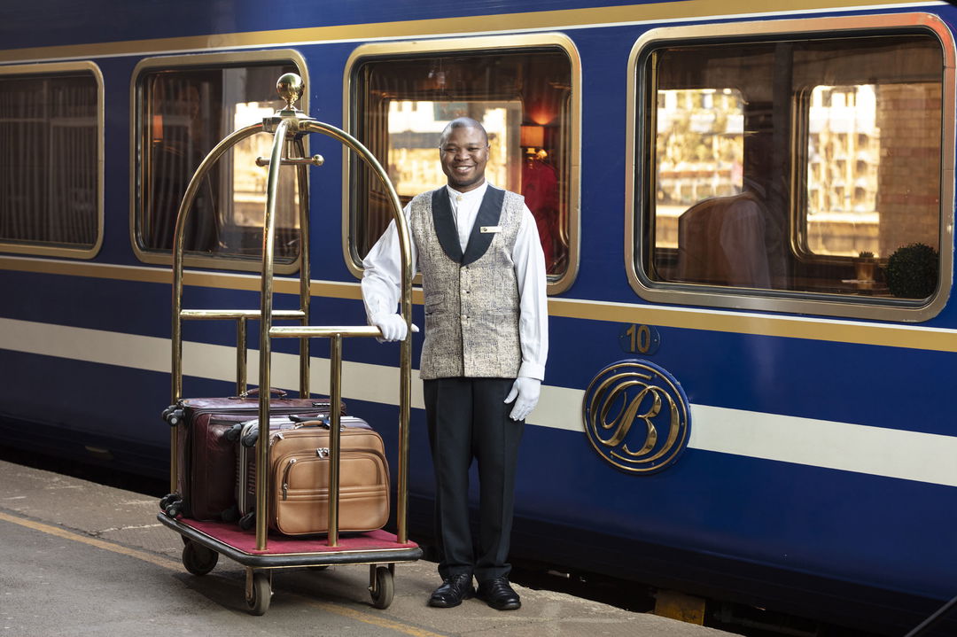 butler with luggage on platform of the blue train Pretoria