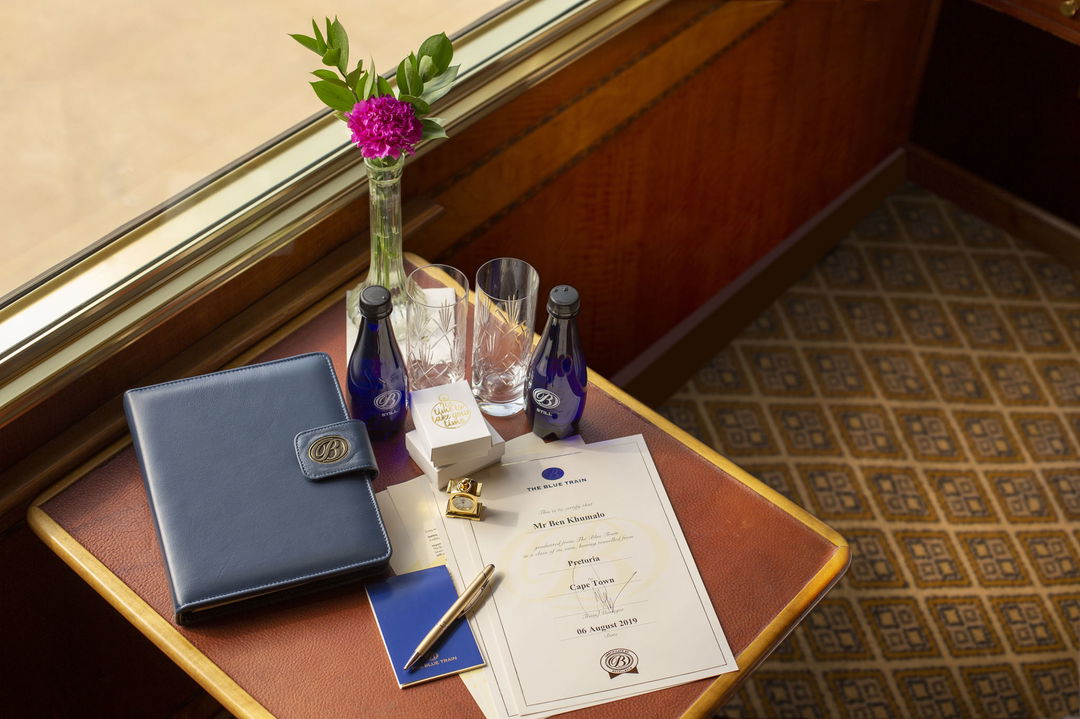 table with travel documents and bottled water on Blue Train South Africa