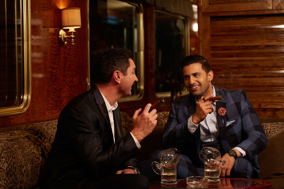 two male guests having cigars and cognac in the lounge area of the Blue Train