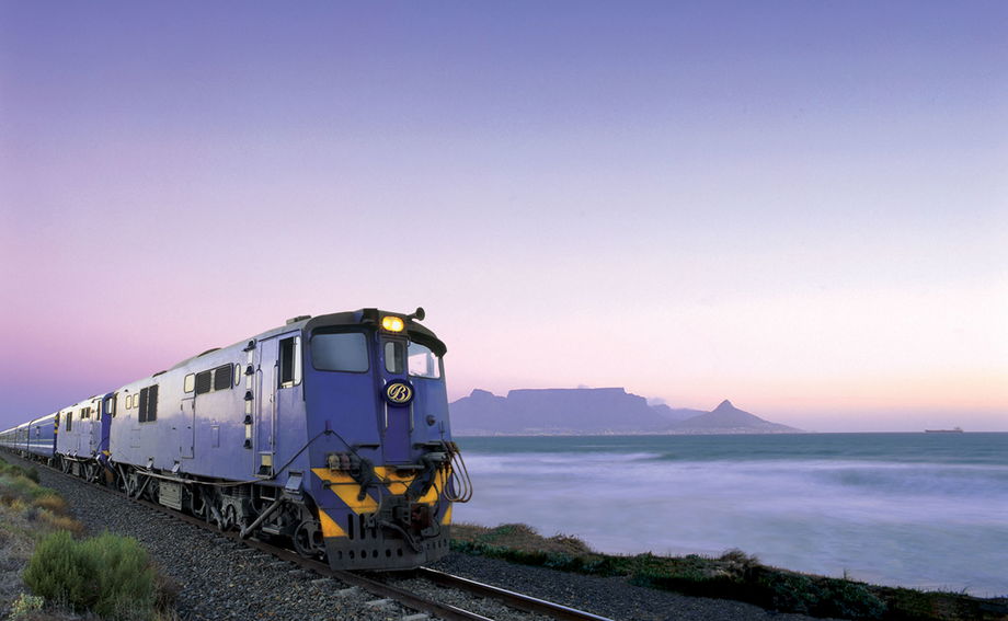 Blue train locomotive at sunset with table mountain cape town in background