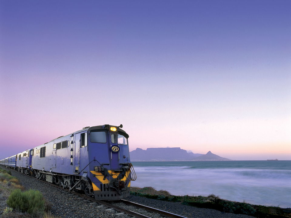 Blue train locomotive at sunset with table mountain cape town in background