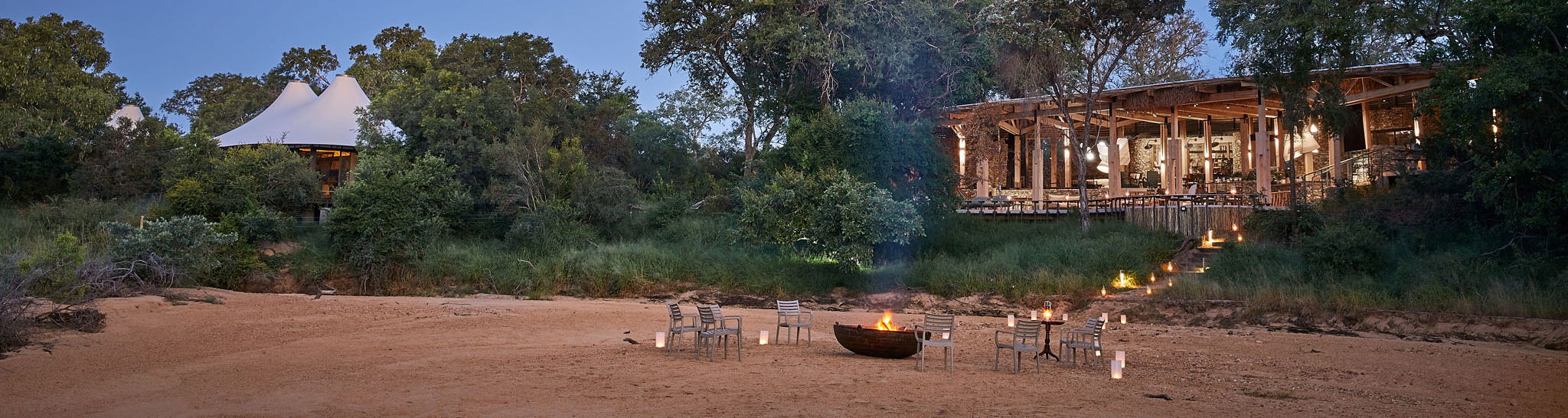 river view of fireplace in front of Thornybush Saseka tented camp at sunset