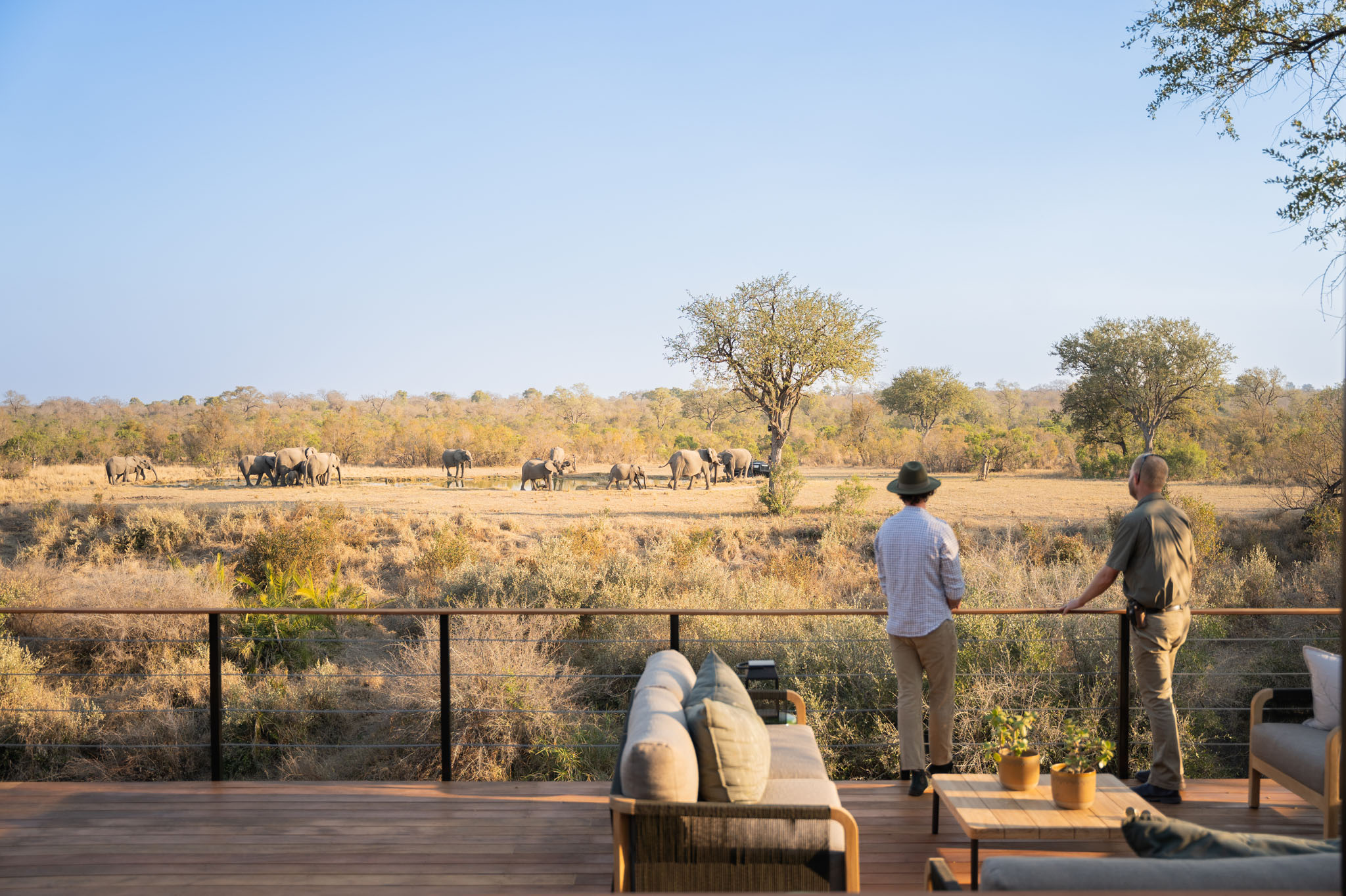two guests on the viewing deck of thornybush camp looking at elephants by waterhole