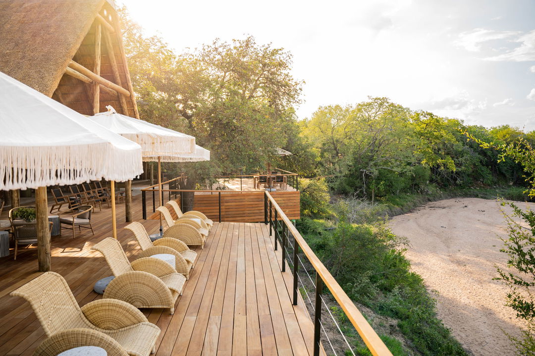 view of Thornybush game lodge deck with chairs along riverbed