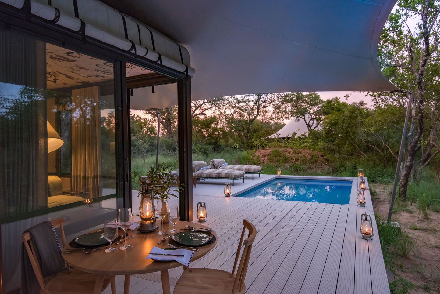 deck with pool and dinner table at Saseka Thornybush at sunset
