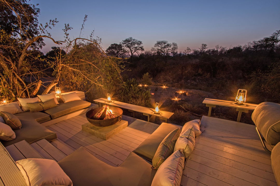 night view private deck with loungers and fireplace at little Saseka luxury safari lodge