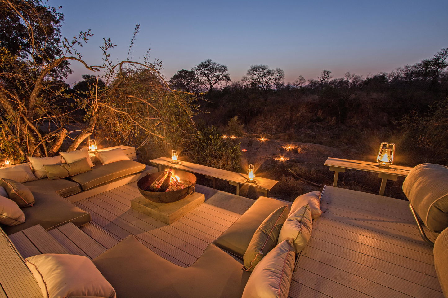 night view private deck with loungers and fireplace at little Saseka luxury safari lodge