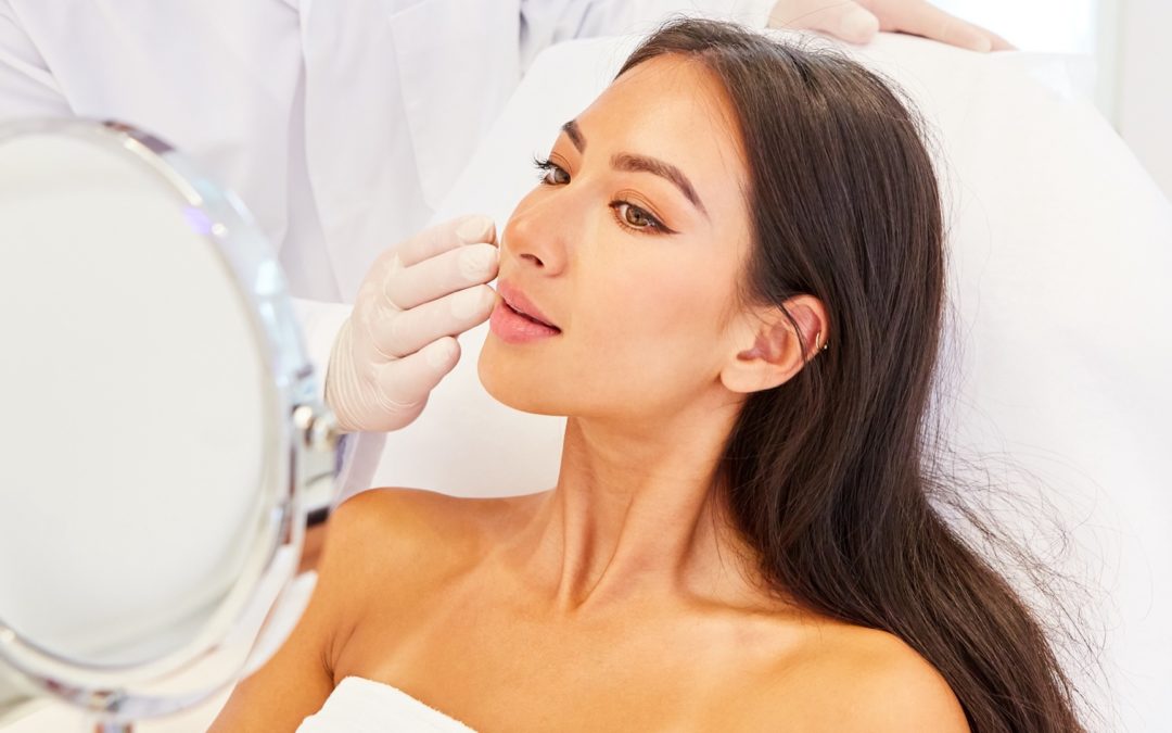 lady holding mirror looking at face post surgery