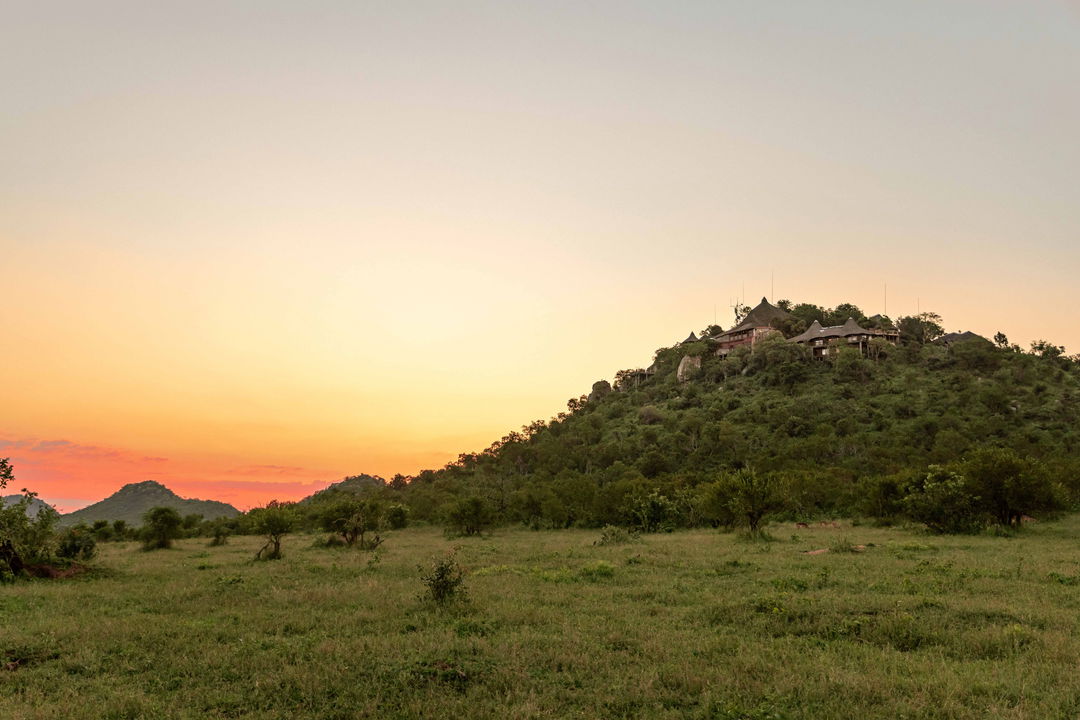 sunset in the valley showing Ulusaba rock lodge in distance