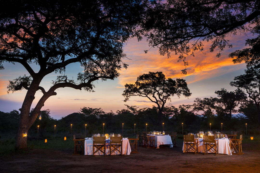 Bush Dinner at Ulusaba luxury safari lodge at night with sunset view in African bush