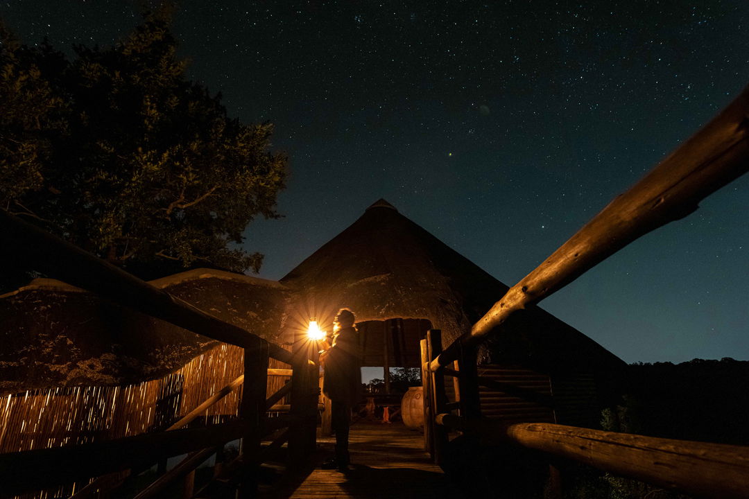 bridge at Ulusaba lodge at knight illuminated with starry sky and guests