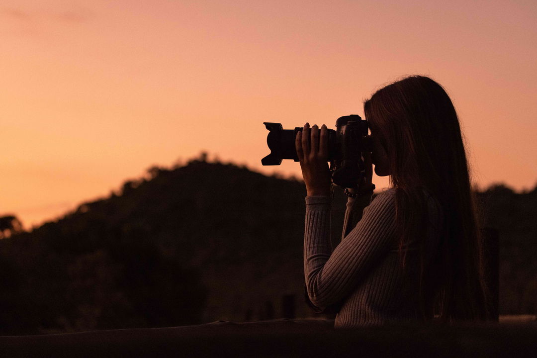 silhouette of lady photographer at sunset filming at ulusaba game lodge