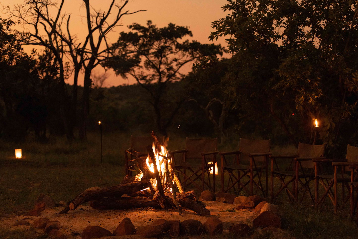 fireplace boma with African sunset in backdrop by Ulusaba safari lodge