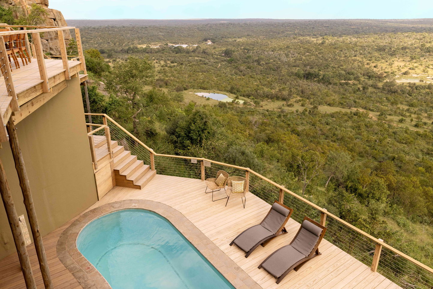 aerial view of cliff lodge room at Ulusaba  with deck chairs and a pool overlooking the valley below