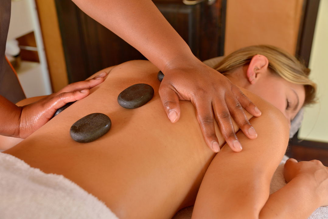 hot stone message on back of lady guest by Victoria falls safari lodge spa
