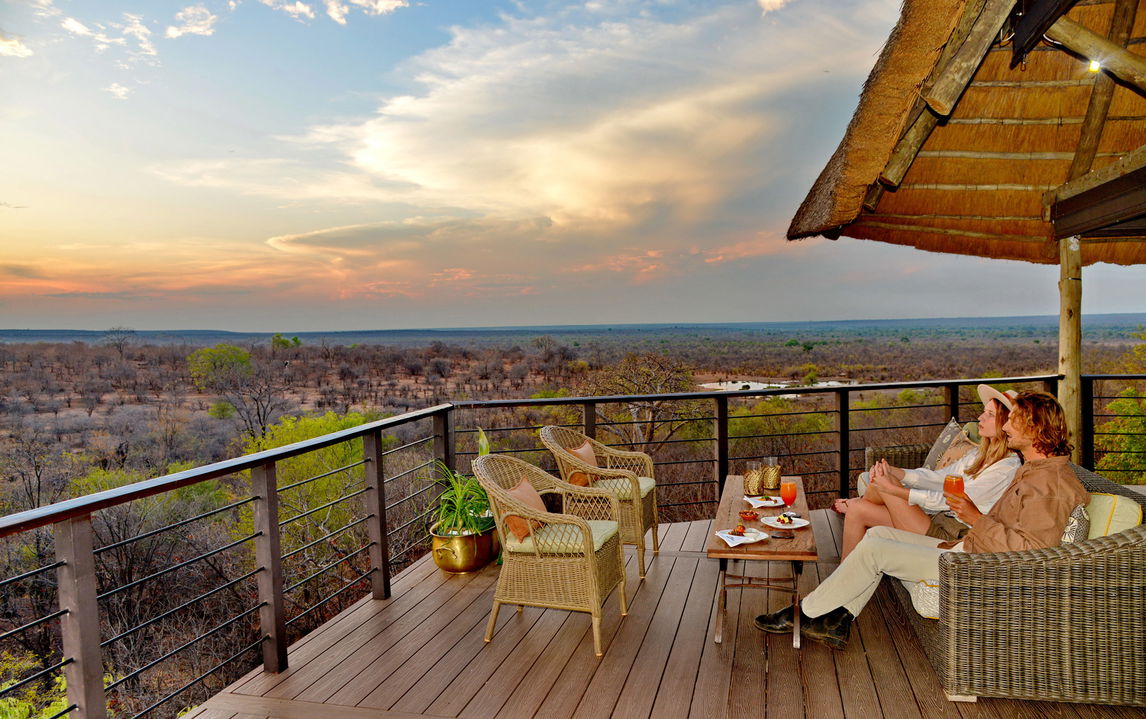 couple having sundowners on the viewing deck of Victoria falls safari lodge