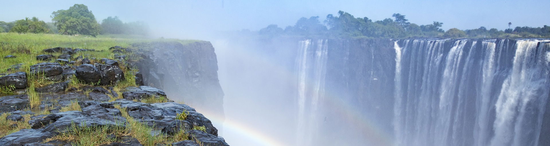 view of entire width of Victoria falls Zimbabwe in full flow with rainbow