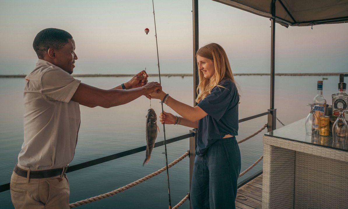 lady guest fishing on barge at wilderness duma tau camp botswana