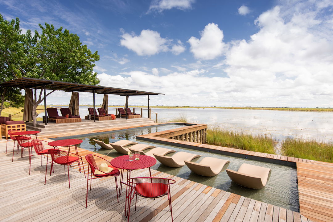 pool deck of osprey retreat with chairs at mid day by wilderness duma tau camp botswana