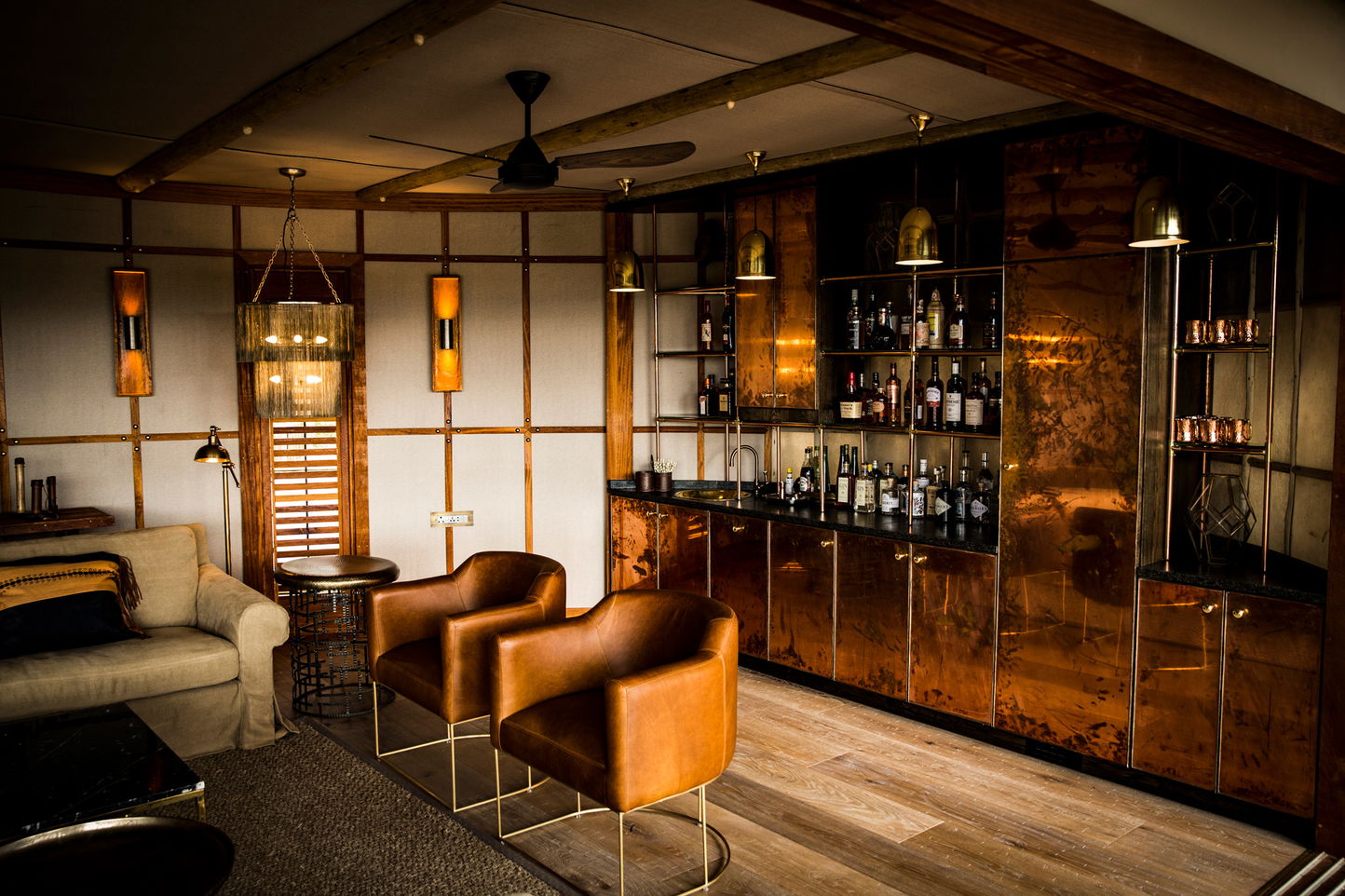 bar facility with leather chairs in main lounge at Okavango Delta by Little Mombo Wilderness
