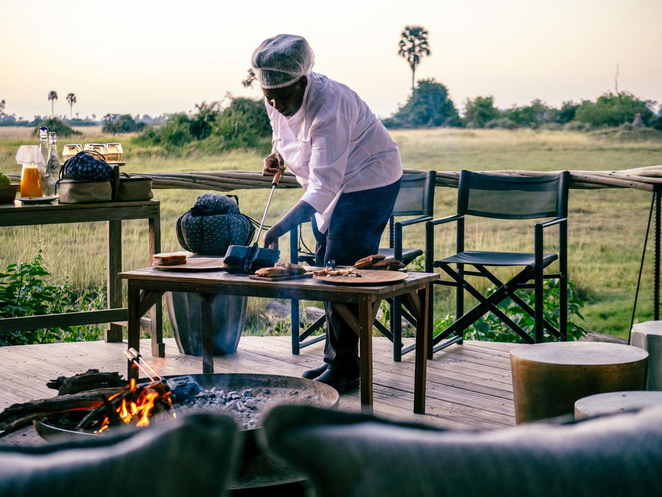 chef preparing food in firepit by Little Mombo Wilderness