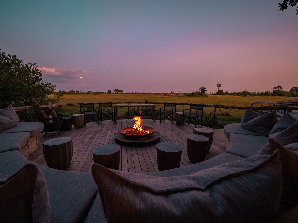 sunset view of fire pit on deck at Okavango Delta by Little Mombo Wilderness