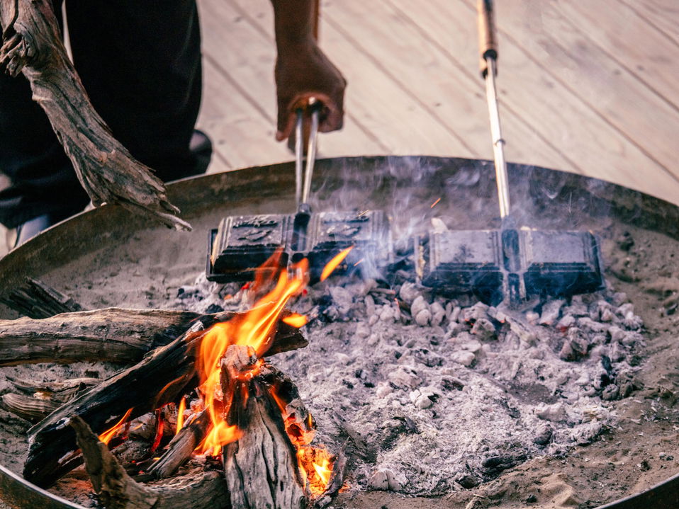 chef preparing jaffles in firepit by Little Mombo Wilderness