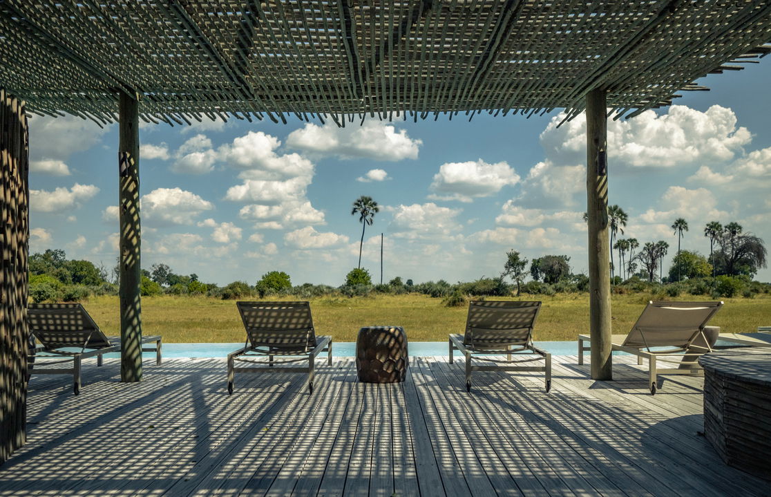 pool deck with loungers and a view of delta at Okavango Delta by Little Mombo Wilderness