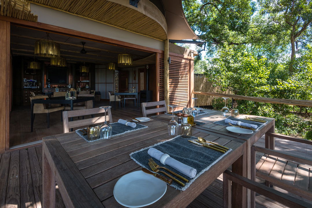 table set for breakfast on private deck of room at Little Mombo camp Wilderness safaris
