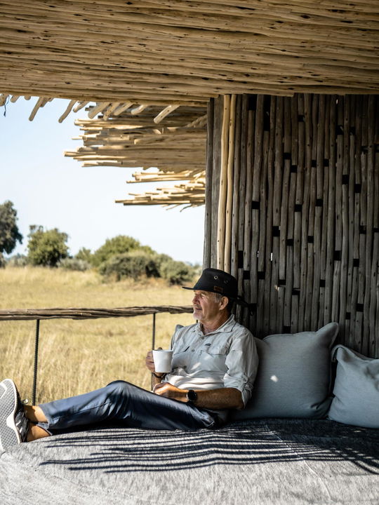 guest on deck viewing delta at Little Mombo camp Wilderness safaris
