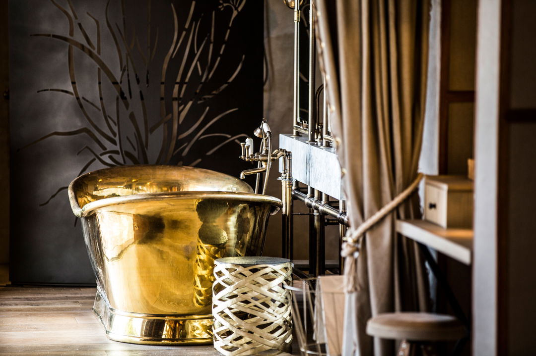  interior view of bathroom and big copper bathtub at Okavango Delta by Little Mombo Wilderness 
