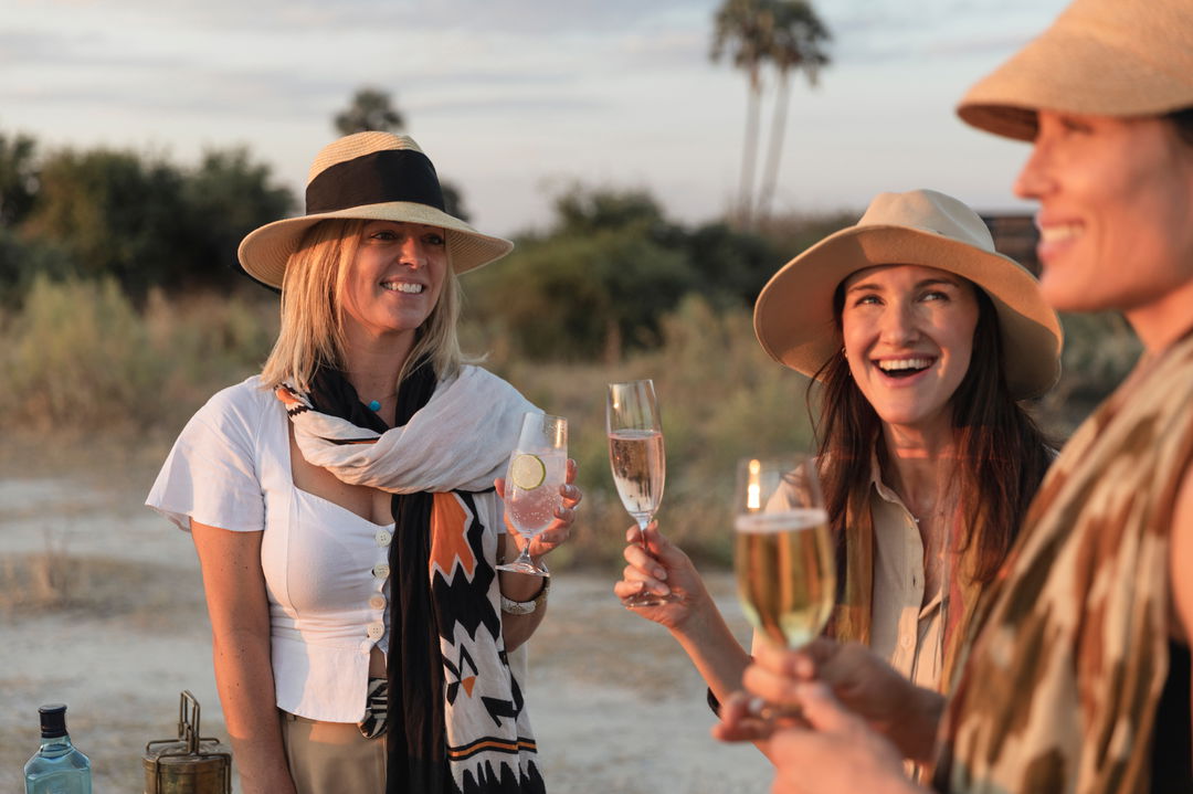 two lady guests having sundowners  at Little Mombo camp Wilderness safaris