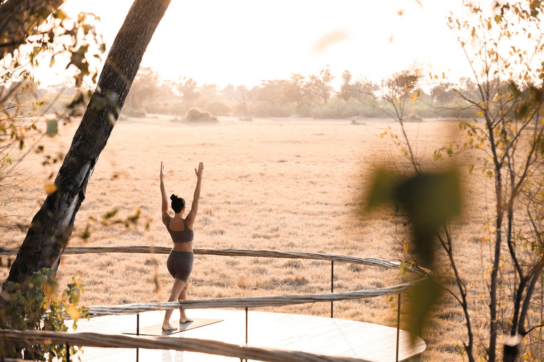 lady doing yoga on deck at Little Mombo camp Wilderness safaris