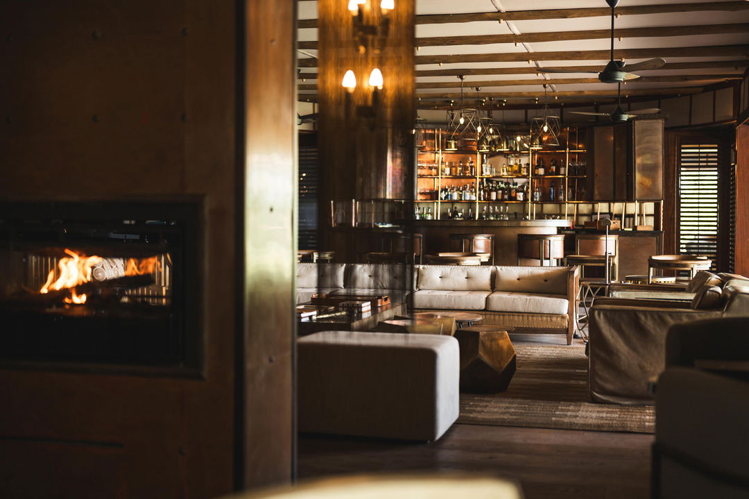 bar and fireplace in lounge of Wilderness Mombo Camp 