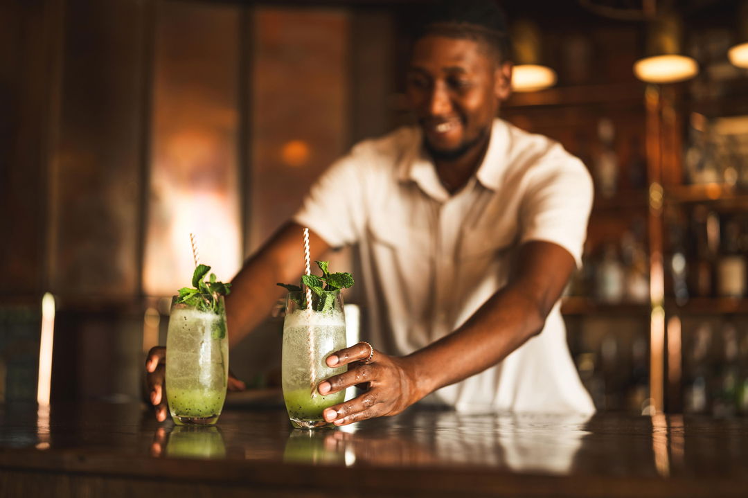 barman serving cocktails at Wilderness Mombo Camp in the Okavango Delta