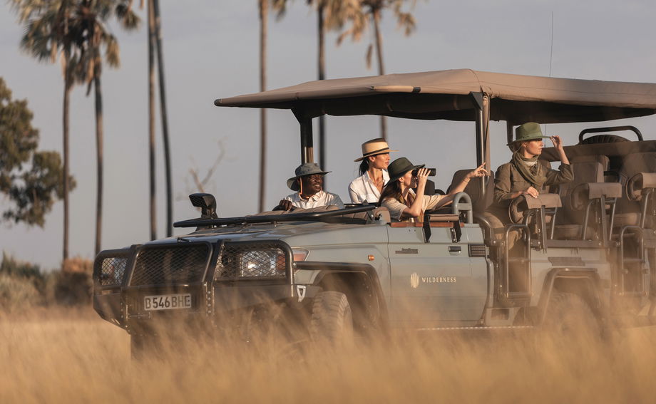 safari vehicle with guests on a game drive at Wilderness Mombo Camp in the Okavango Delta