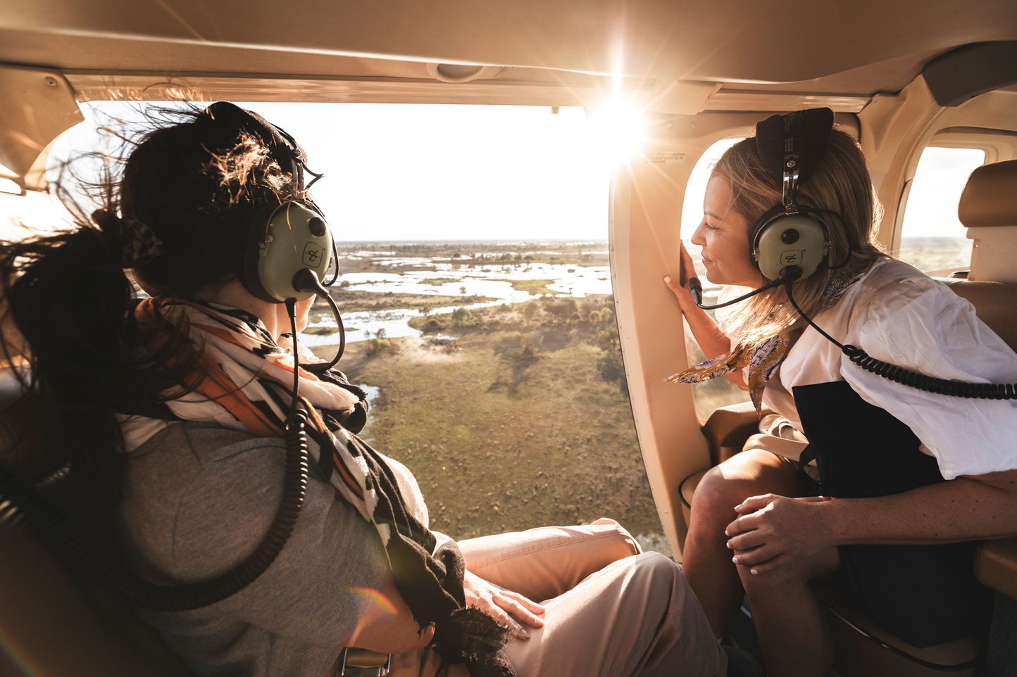 two guests in helicopter over the Okavango delta at Wilderness Mombo Camp