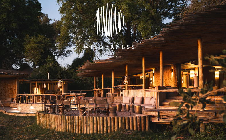 view from below of viewing deck at sunrise on the Okavango delta at Wilderness Mombo Camp with wilderness logo overlay view from below of viewing deck at sunrise on the Okavango delta at Wilderness Mombo Camp with wilderness logo overlay