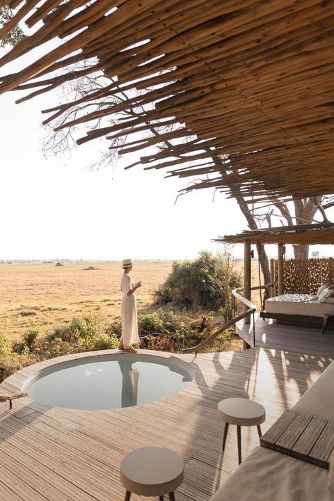lady on patio deck by splash pool at Mombo camp Botswana