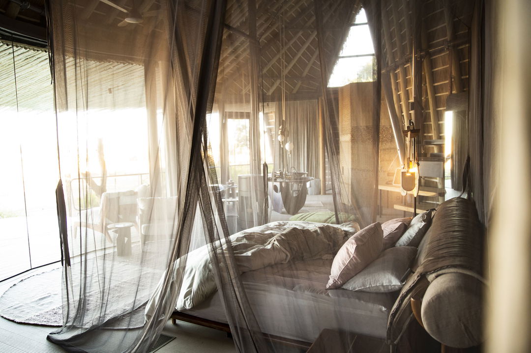 interior view of luxury room with big bed and deck beyond at Jao Camp Wilderness Okavango Delta Botswana