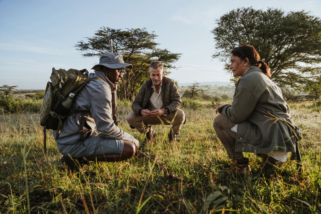 ranger and guests sitting on plains by Wilderness Usawa tented camp Serengeti